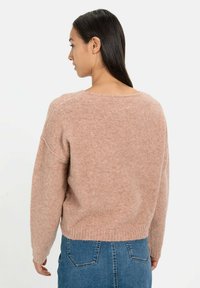 Roze, zachte gebreide trui met een ronde halslijn, doorgezakte schouders en een cropped silhouet. Beschikt over geribbelde mouwen en zoom.