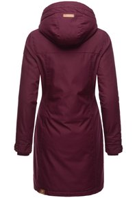 Parka bordeaux avec capuche, manches longues, poignets boutonnés et un tissu texturé. Dotée d'un patch logo près de l'ourlet.