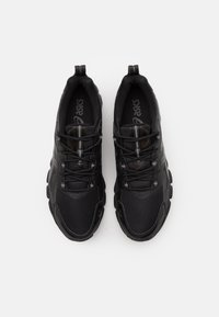 Sneaker sportivi neri con una tomaia in mesh, colletto imbottito e suola in gomma. Presentano dettagli riflettenti e un design con lacci.