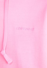 Felpa rosa realizzata in tessuto morbido e strutturato, con cappuccio regolabile e logo "carhartt" ricamato sul petto.