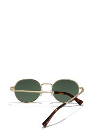 Gafas de sol de metal dorado con lentes verdes. Forma redonda con un puente delgado, que presenta varillas de acetato carey y almohadillas nasales transparentes.