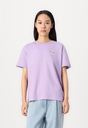 Camiseta de algodón lavanda con un corte relajado, mangas cortas, cuello redondo y un pequeño diseño bordado en el pecho.