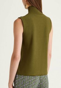 Col roulé sans manches vert olive en maille texturée, avec un col haut et une silhouette ajustée.