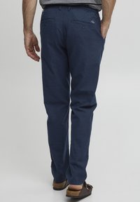 Navy blue, kevyttä puuvillaa olevat housut suoran lahkeen muotoilulla, joissa on kaksi takataskua ja hienovarainen rakenne.