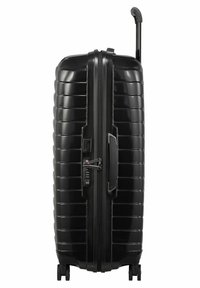 Valise rigide noire avec texture rainurée, poignée télescopique, fermeture éclair avant et serrure à combinaison. Équipée de quatre roues pour une meilleure mobilité.