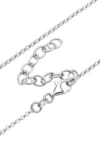 Chaîne en argent sterling avec des maillons entrelacés, un fermoir en forme de homard et une étiquette marquée "925". Le design est lisse avec une finition brillante.