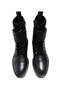 Czarne botki za kostkę wykonane z gładkiej skóry, z pikowanym kołnierzem, sznurowanym przodem, złotymi oczkami i teksturowaną podeszwą.