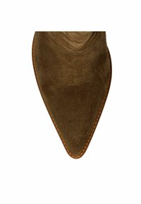 Pointed toe of brown suede shoe with visible stitching along the edge of the sole against a white background.