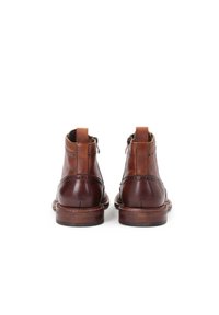 Botine din piele maro până la gleznă, cu detalii brogue, talpă cusută și fermoar posterior. Textură netedă cu finisaj lustruit.