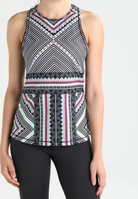 Sportovní top bez rukávů s geometrickými vzory v černé, bílé a mátové barvě, zaobleným výstřihem a designem na zádech racerback, doplněný těsným střihem.