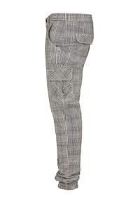 Pantalon cargo à carreaux gris et blanc avec plusieurs poches à rabat et poignets élastiqués aux chevilles, vu de profil.