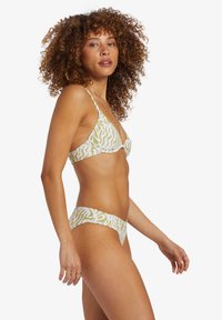Groen en wit gestreepte bikini met een trianguleerde bralette met verstelbare bandjes en bijpassende lage shorts, gemaakt van rekbaar materiaal.