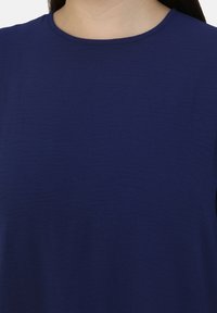 Marineblaue, kurzärmlige Bluse aus strukturiertem Stoff mit rundem Halsausschnitt. Weiches, leichtes Material mit lässiger Passform.