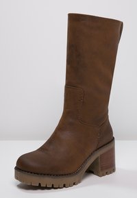 Botte en cuir marron jusqu'au genou avec un talon épais, finition texturée, bout arrondi et semelle crantée pour l'adhérence. Présente des détails de couture subtils.