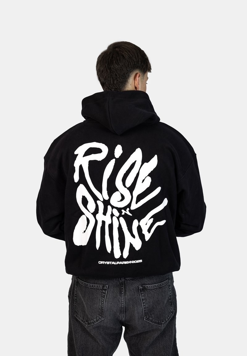 Felpa nera con cappuccio caratterizzata da una grande scritta bianca stampata "RISE & SHINE" sul retro. Il design ha una vestibilità ampia e una tasca a marsupio.