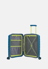 Valigia rigida blu con una cerniera gialla a contrasto, scompartimenti interni, divisore in rete e quattro ruote per la mobilità.
