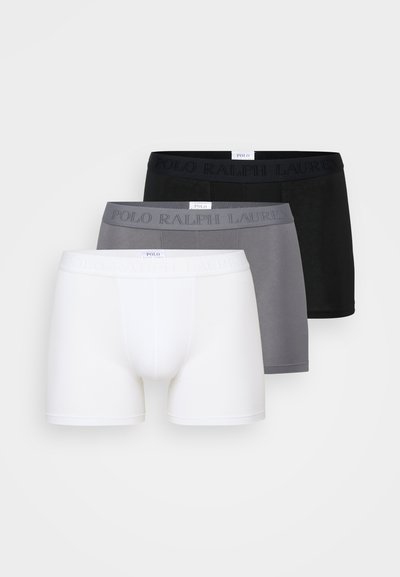 Três pares de boxers em branco, cinza e preto. Feitos de um tecido macio com cinturas elásticas apresentando o texto em relevo "POLO RALPH LAUREN".