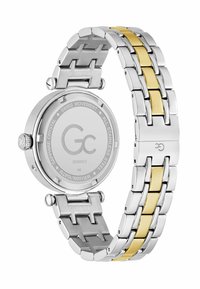 Roostevabast terasest kell, millel on hõbe- ja kuldse linkidega käevõru, ümmargune korpus ja sile, peegeldav pind. Tagaküljel on näha "GC" logo ja detailid.