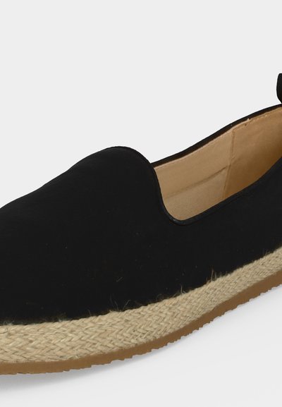 Espadrille noire à enfiler avec semelle en jute tressée beige et doublure intérieure couleur cuir clair, montrée en angle latéral sur fond blanc.
