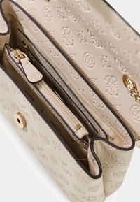 Borsa beige in pelle sintetica testurizzata, con motivo logo in rilievo, finiture dorate e tasca interna con cerniera.