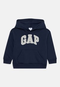 Námořnická modrá mikina vyrobená z bavlny, s přední kapsou, žebrovanými manžetami a nápisem "GAP" v bílém a béžovém filcu.