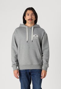 Grauer Hoodie aus weichem Material, mit einer Vordertasche, verstellbarem Kordelzugacker und einem kleinen gestickten Logo auf der Brust.