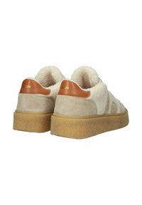 Beige und cremefarbene Sneakers mit flauschiger Textur, Wildleder- und Lederakzenten sowie einer dicken Gummisohle. "BACKSTN" in Gold auf der Ferse gedruckt.