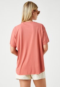 Rosa, kortærmet t-shirt med en afslappet pasform og blød tekstur, der har en rund halsudskæring og en lidt længere baghem.