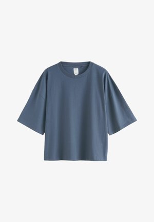 T-shirt ample à manches courtes en coton bleu foncé. Il présente un col rond et une silhouette décontractée, avec une texture lisse et sans motifs visibles.
