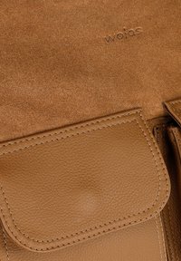 Bruine leren handtas met een gestructureerd oppervlak, gladde accenten en een klepclosure met geborduurde details. Geëmbosseerd logo aanwezig.