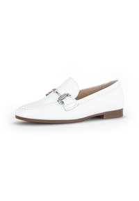 White leather loafers with a flat sole and a decorative silver buckle. Rounded toe and contrasting stitching detail. Soft texture on surface.