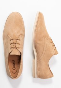 Beige suède veterschoenen met een gladde afwerking, ronde neus en lichte rubberen zool. Gabor-logo zichtbaar op de binnenzool.