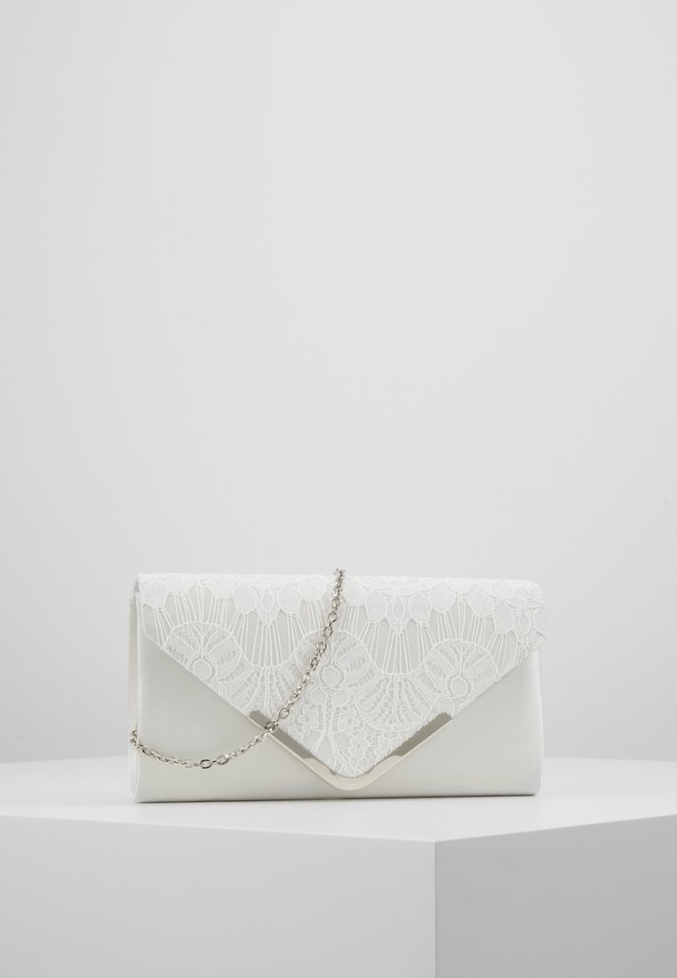 Pochette blanche avec rabat en dentelle, bordure argentée et délicate bandoulière en chaîne argentée, exposée sur un piédestal géométrique blanc sur fond uni.
