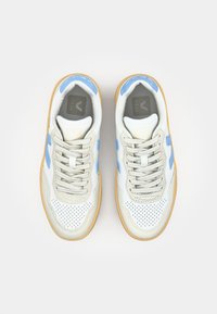 Baskets blanches et bleu clair avec une tige en cuir perforé, des accents beiges et une semelle en caoutchouc naturel. Dotées de lacets ronds et d'un logo sur la languette.