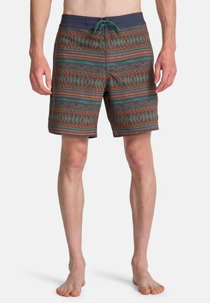 Pantaloncini da bagno con motivo geometrico in verde, arancione e grigio. Presentano una vita con coulisse e un taglio a metà coscia. Tessuto dalla trama liscia.