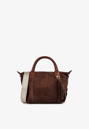 Bolso de ante marrón con asas de cuero marrón oscuro, un gran tassel y una correa para el hombro beige claro con texto en relieve.