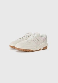 Vita mockasinsneakers med ljusrosa accenter, en texturerad ovansida och en gummisula. Har snören och varumärke på sidopanelen.