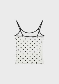 Haut camisole blanc à pois noirs, fines bretelles noires et bordure noire le long de l'encolure et des bretelles.