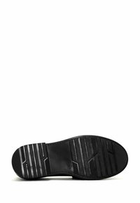 Suela de zapato de goma negra con un patrón de textura en la superficie. Presenta una puntera redonda y un diseño plano, adecuado para uso casual.