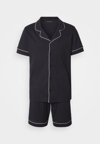 Μαύρο βαμβακερό σετ πιτζάμες με κοντά μανίκια και σορτς. Διαθέτει λευκή περίγραμμα στο γιακά, τα μανίκια και το τελείωμα. Κουμπώνει μπροστά. Απλός σχεδιασμός.