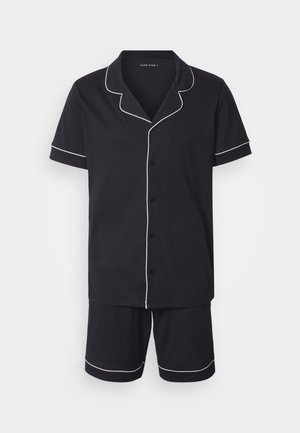 Melns kokvilnas pidžamas komplekts ar īsām piedurknēm un šortiem. Apkaklei, piedurknēm un apakšmalai baltas apmales. Pogājams priekšpusē. Vienkāršs dizains.