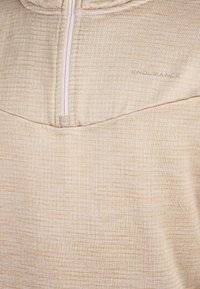 Tessuto beige testurizzato con una zip verticale parziale e il logo "ENDURANCE" stampato nella parte superiore destra.