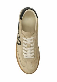 Beige suède sneaker met zwart lederenaccent, ronde neus, witte veters en een gestructureerde rubberen zool. Heeft gestikte details en een logo op de tong.