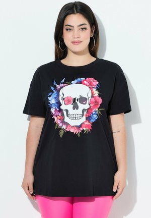 Schwarzes Baumwoll-T-Shirt mit einer großen Totenkopf-Grafik, umrahmt von lebhaften floralem Design in Rosa, Blau und Grün. Kurze Ärmel, lockere Passform.