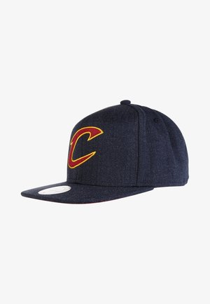 Donkerblauwe honkbalpet met een groot rood en geel "C"-logo aan de voorkant en een vlakke klep met een witte sticker.