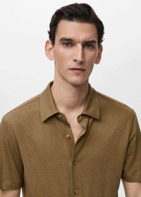 Polo shirt marrone a maniche corte realizzato in un tessuto testurizzato, con colletto e placket anteriore a cinque bottoni.