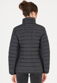 Svart puffjacka med hög krage, horisontellt quiltat mönster och elastiska ärmslut. Slät textur med en åtsittande silhuett.