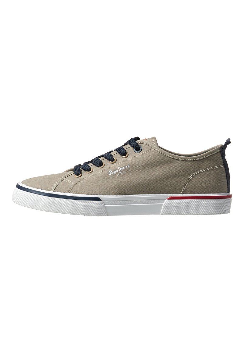 Zapatillas de lona beige con cordones azul marino, suela de goma blanca y acentos rojos y azul marino en el talón. Presenta un logotipo en el lado.