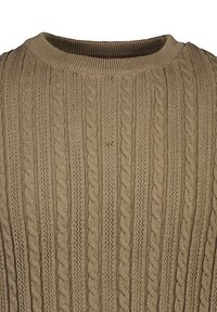 Beige stickad tröja med ribbad rundhals och texturerade flätmönster. Har vertikala ränder med olika texturer för extra detalj.