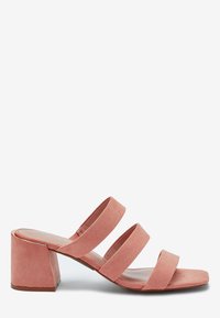 Sandales à talons en daim rose avec trois larges lanières et un talon bloc. Le talon présente une finition lisse avec des accents métalliques subtils.